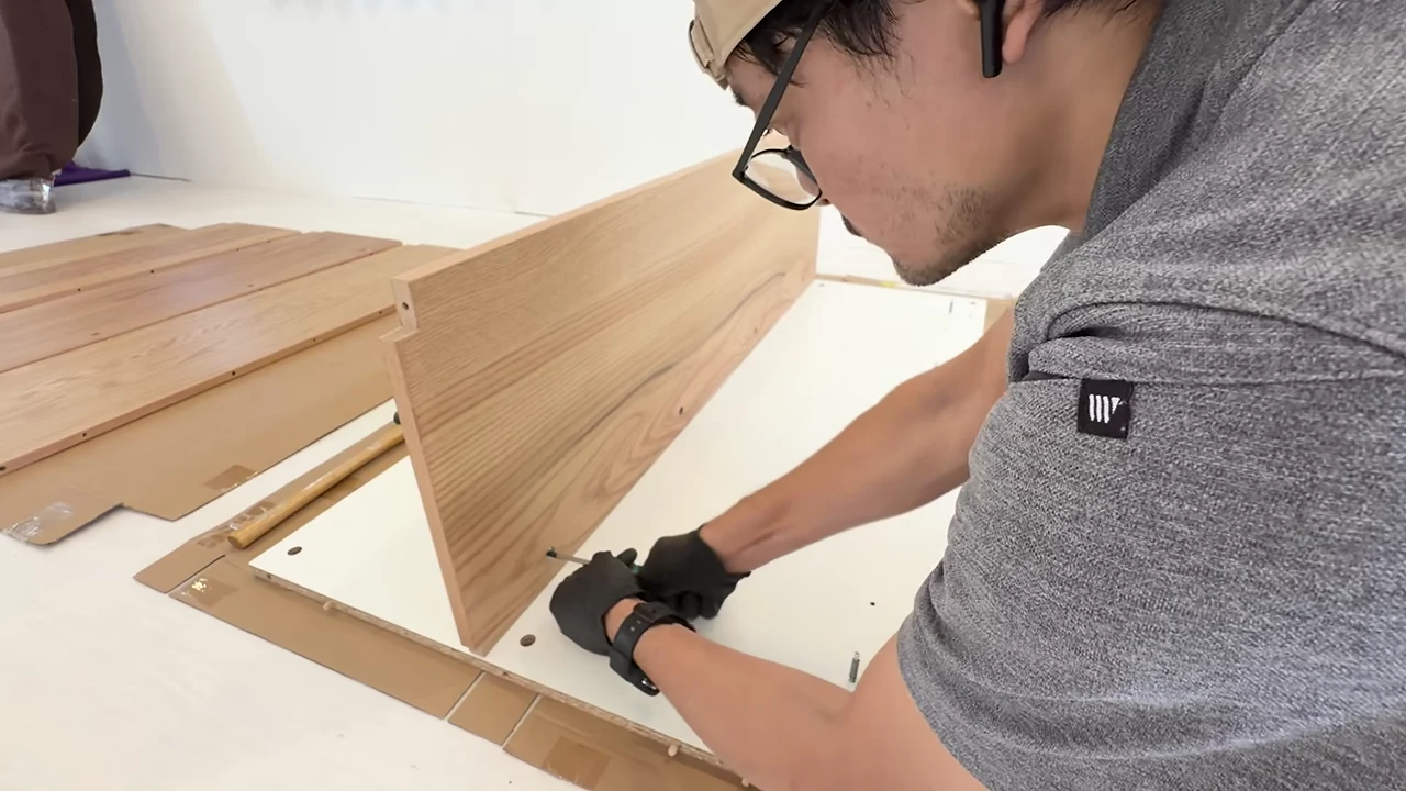 キッチンの部材を手で組み立てる作業風景
